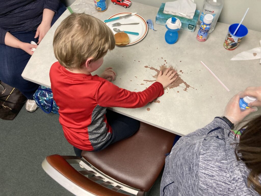 Carter playing with PediaSure on a table as part of an exercise.