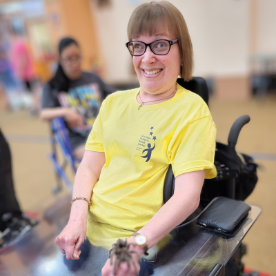 Katie Martin smiling and wearing a yellow t-shirt.