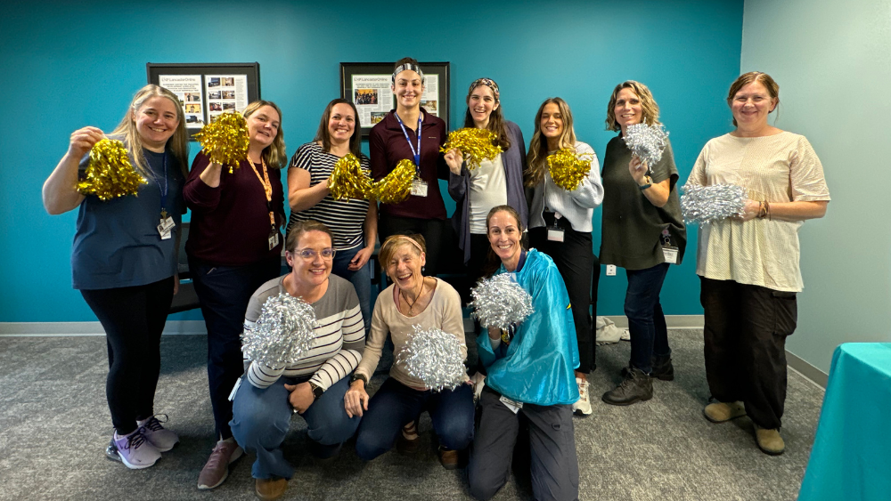 women posing excitedly for photo with pom poms