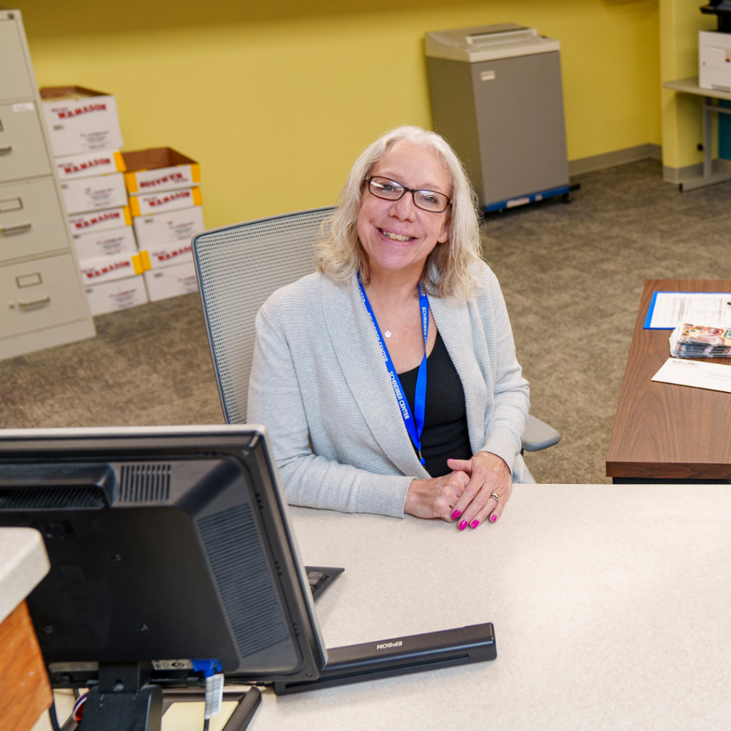 Woman at a desk smiling.