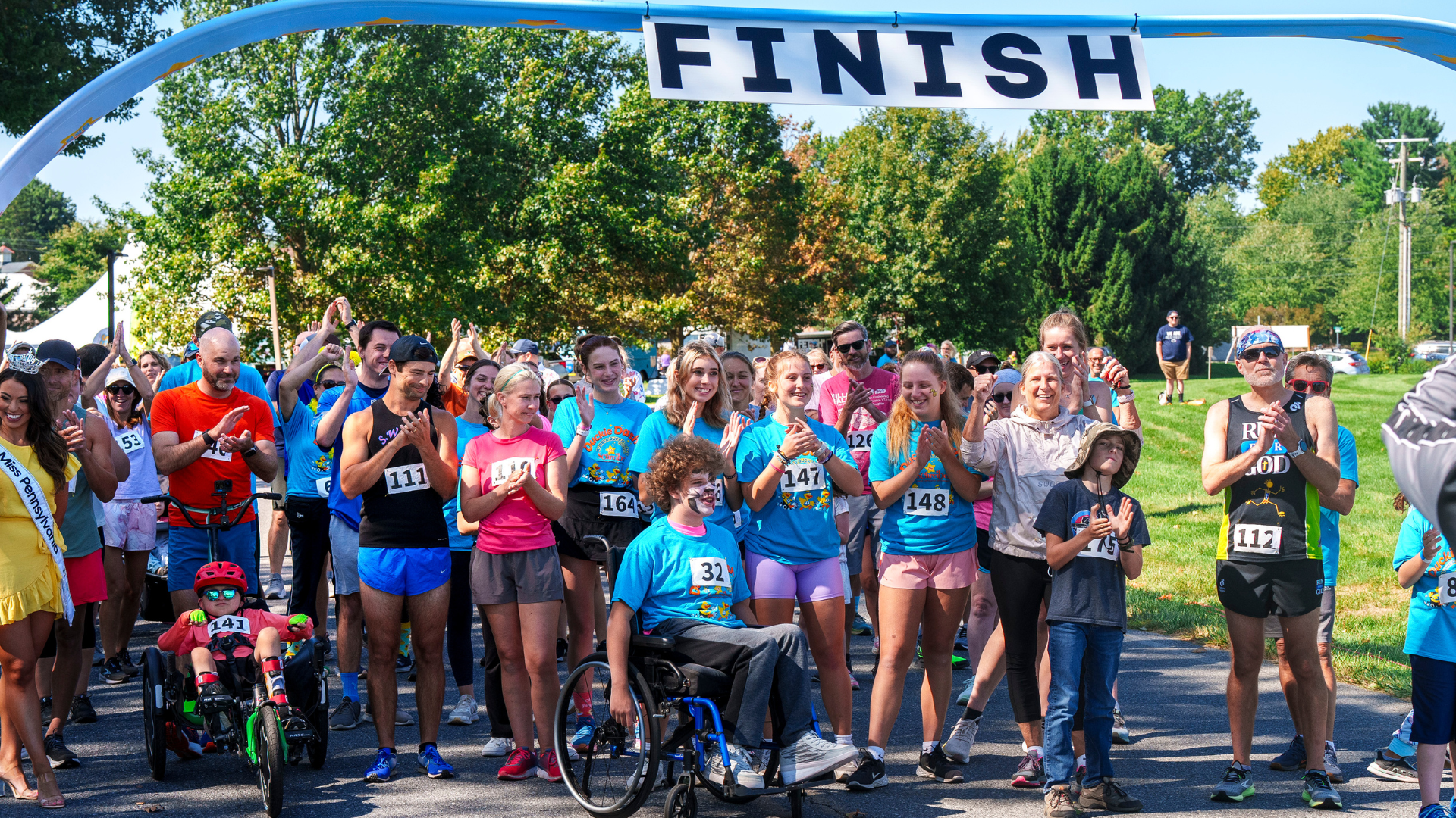 A large group of people under a finish line banner at the rubber duckie event.