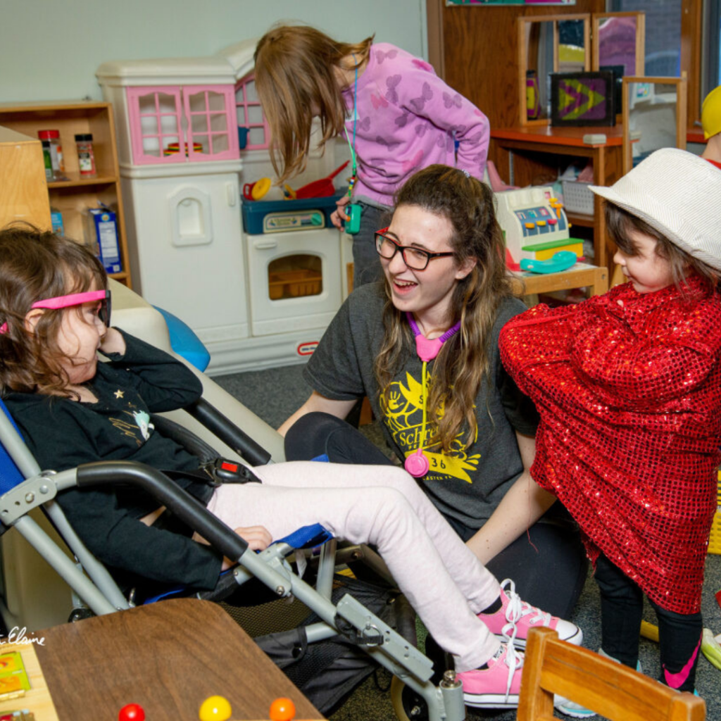 Three kids and an adult playing in a playroom during respite night at Schreiber Center.