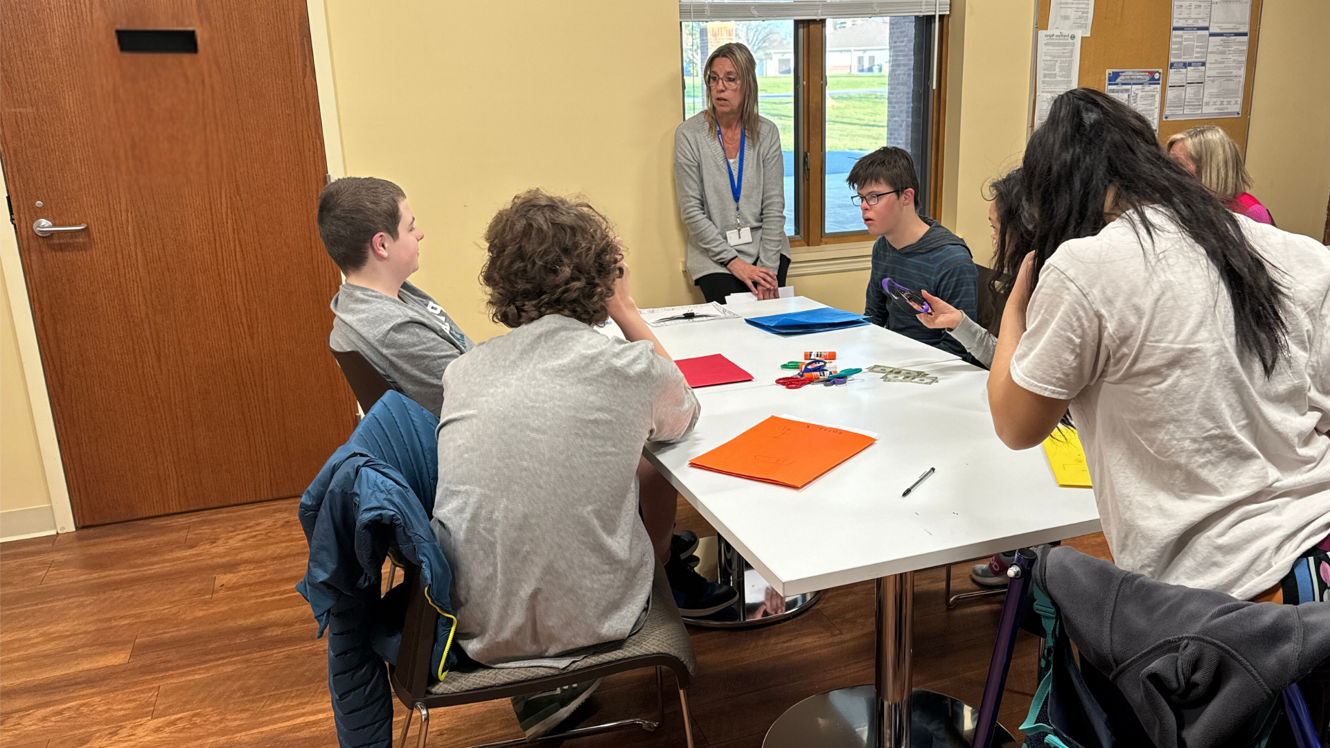 staff and students at table working on a project