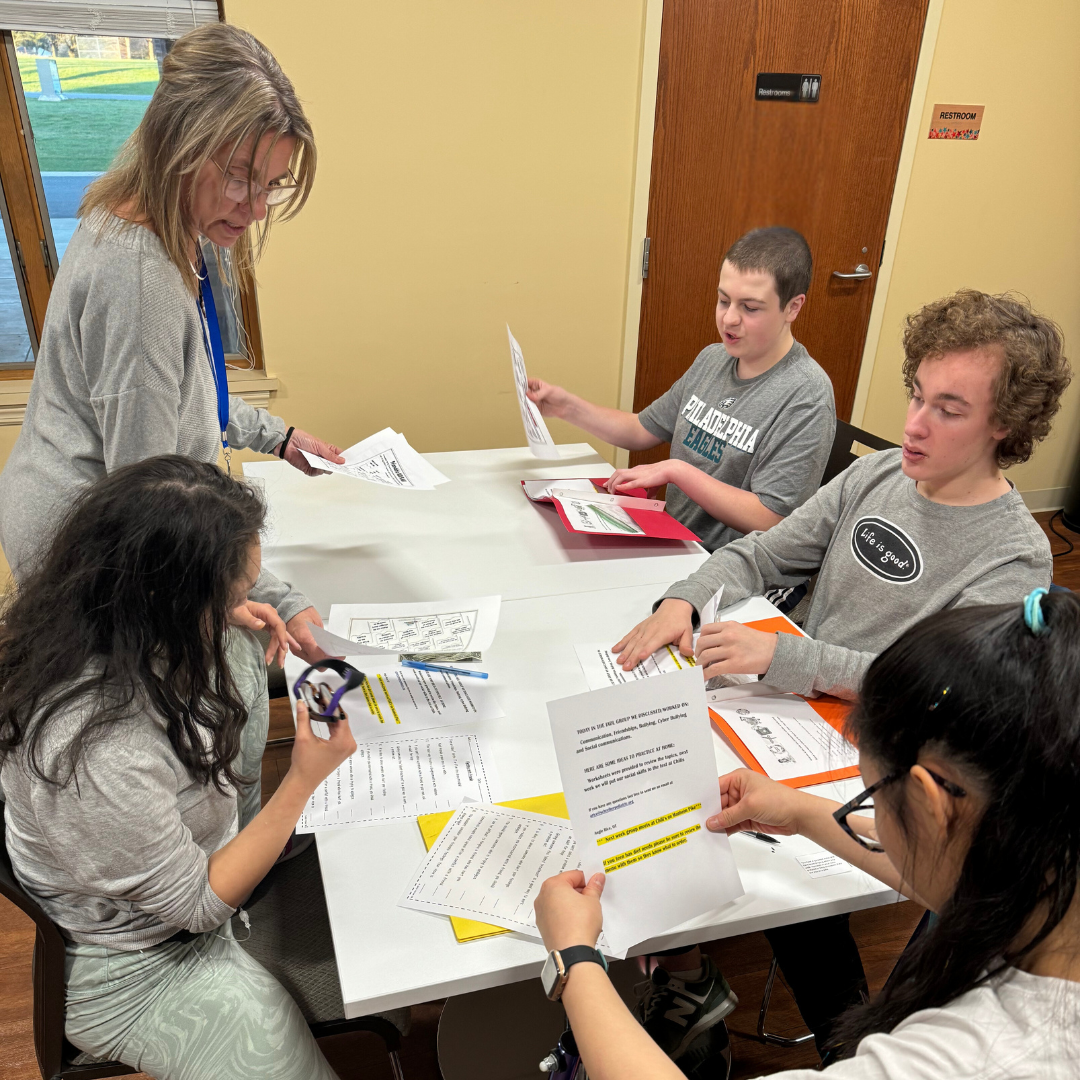 staff and students working around table looking at papers