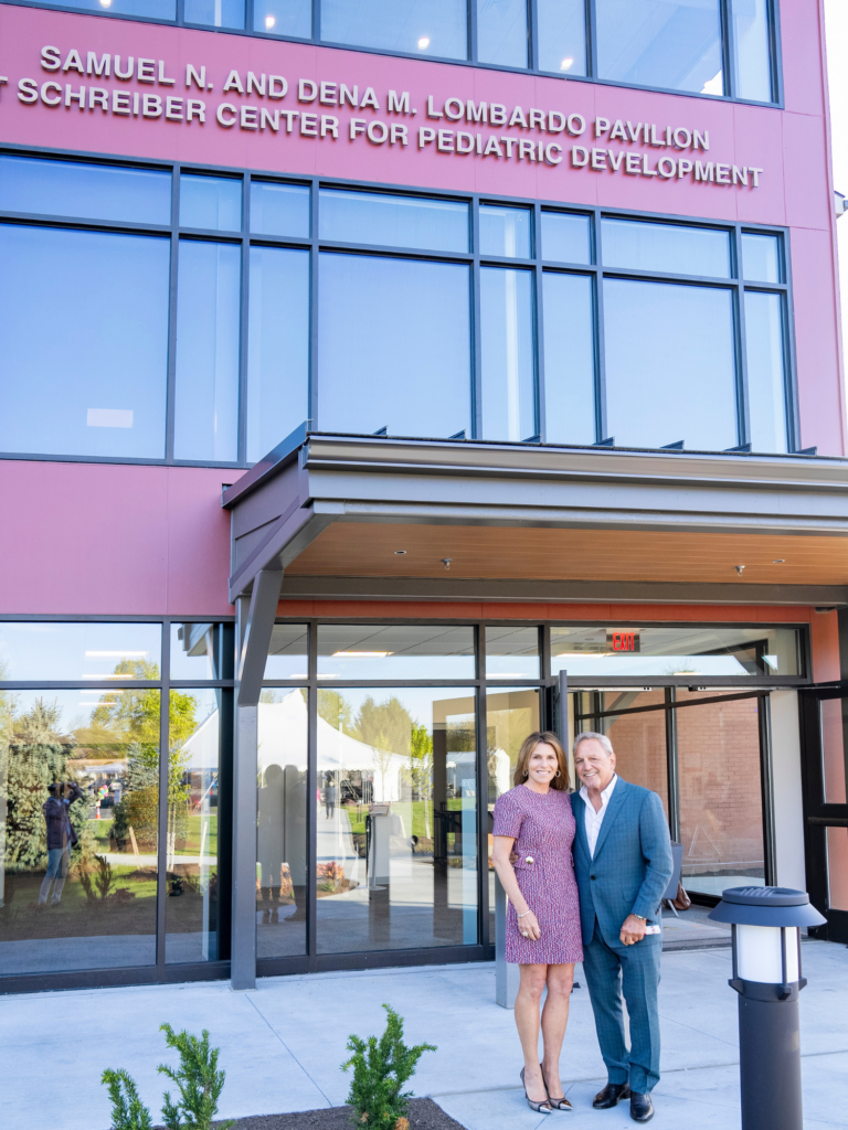 Samuel and Dena Lombardo standing in front of the Lombardo Pavilion at the Schreiber Center for Pediatric Development.