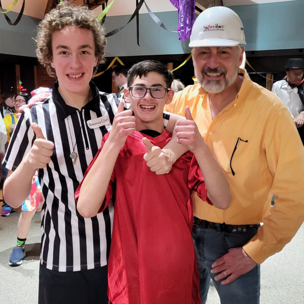 man in hard hat, boy in ref uniform and schreiber kid giving the the thumbs up at an event