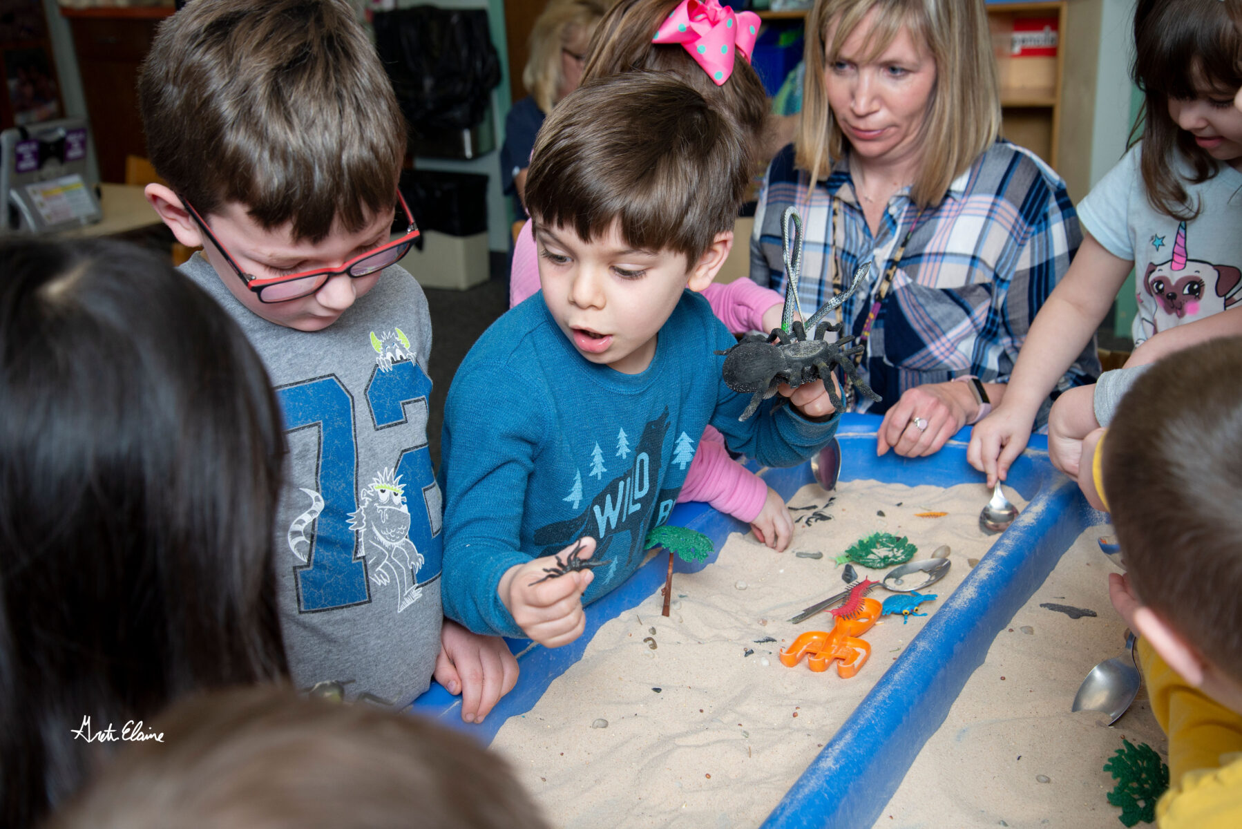 students crowded around each other to work on a craft project