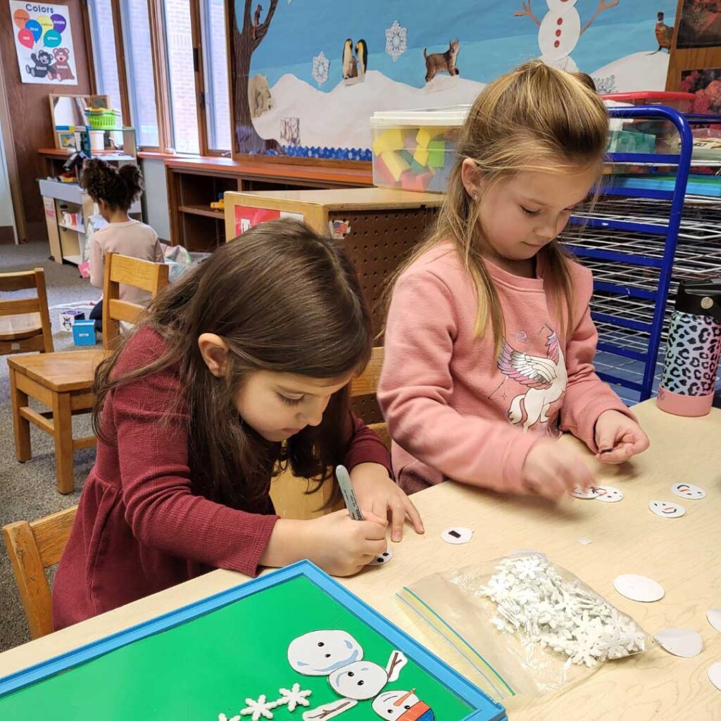 two girls working on a project in classroom at desk