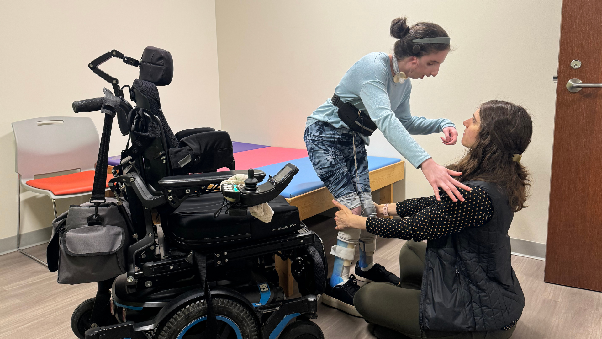 staff member supporting girl as she gets out of wheelchair