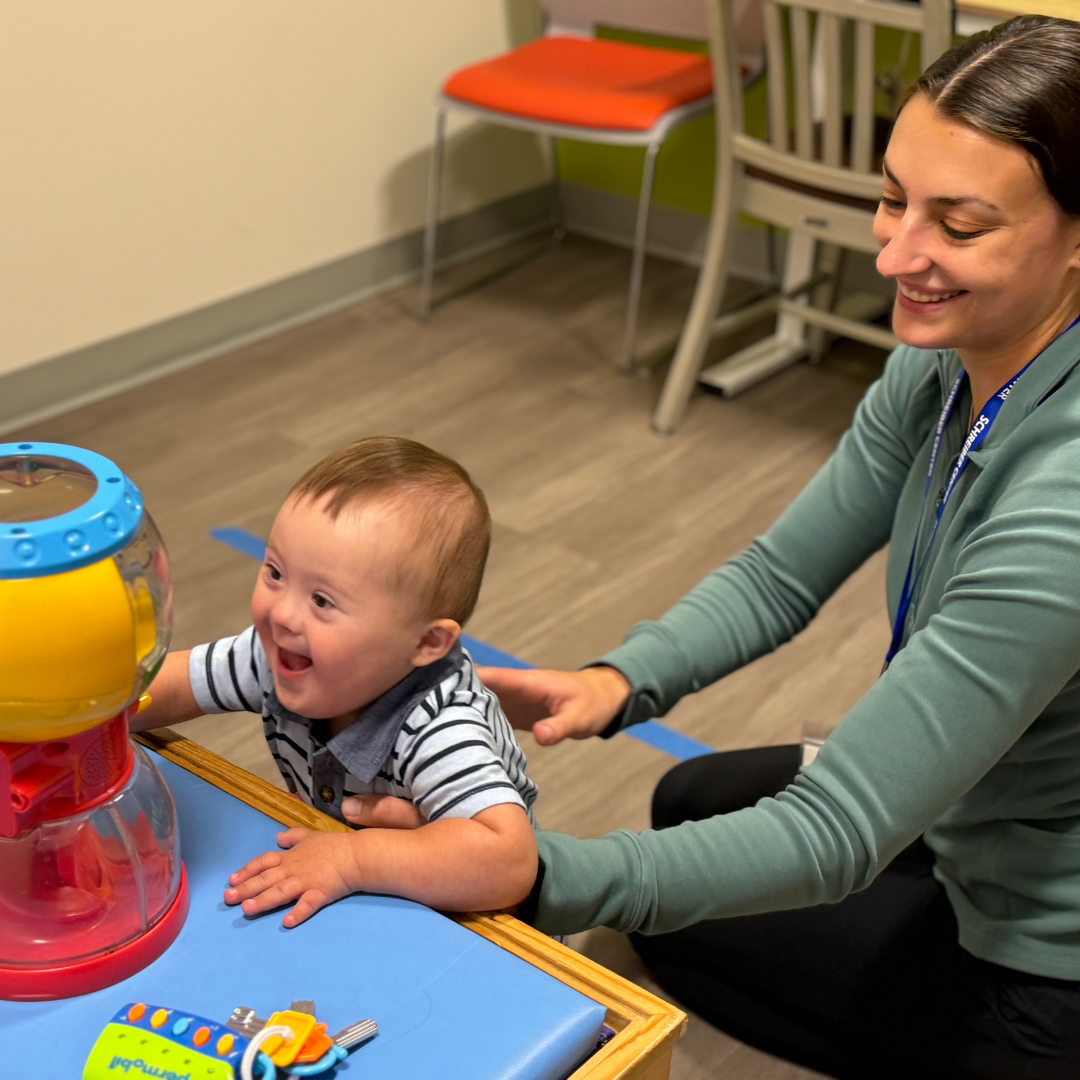 Therapist and child performing physical therapy exercise.