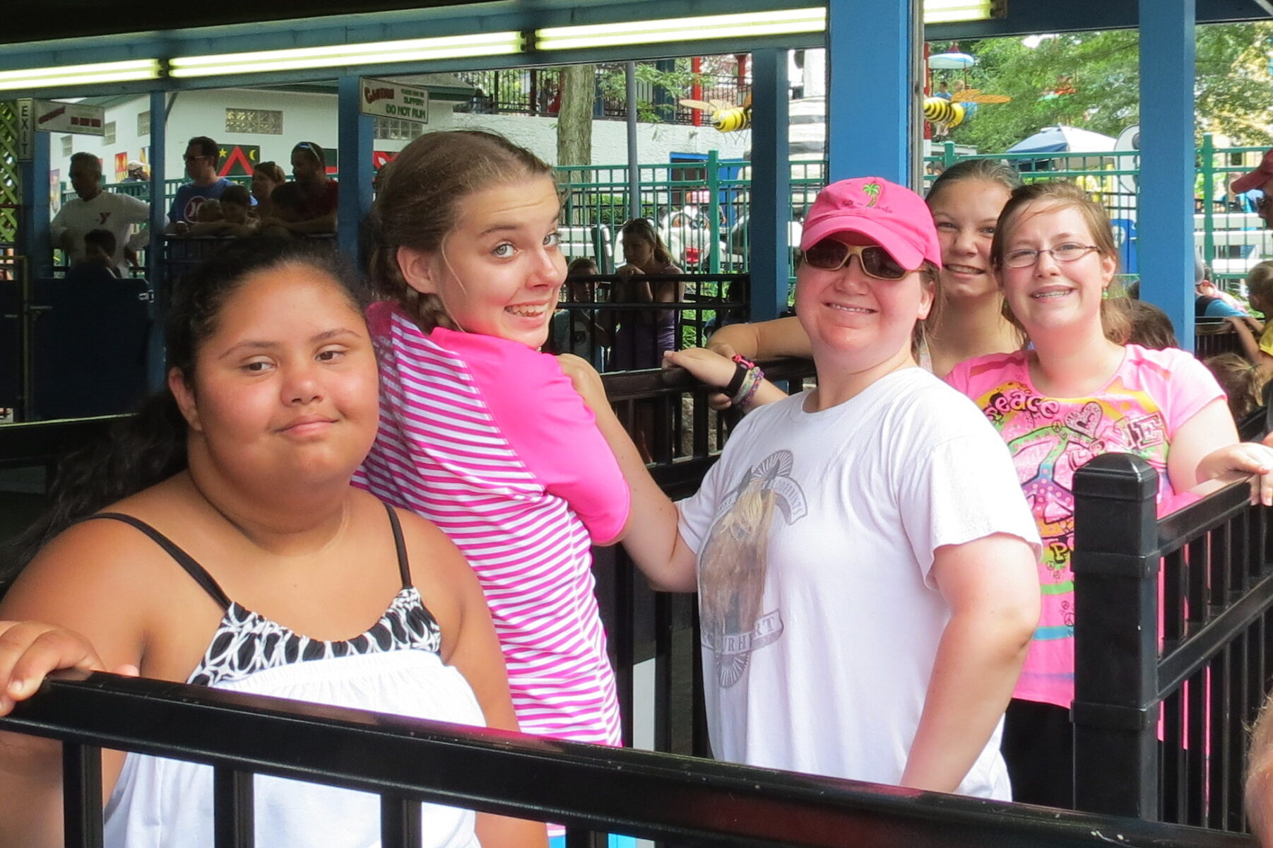 Four tweens waiting in line at an amusement park.